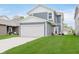 Two-story home with blue siding, white trim, and a two-car garage with a small patio and lawn at 6460 Wasco Dr, Whitestown, IN 46075