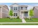Charming two-story home featuring stone accents, blue siding, a well-manicured lawn, and sidewalk at 6460 Wasco Dr, Whitestown, IN 46075