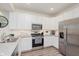 A well-equipped kitchen showcasing stainless steel appliances, white cabinetry, and granite countertops at 6460 Wasco Dr, Whitestown, IN 46075