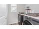 Modern laundry room with gray washer and dryer set with shelving and a window at 6460 Wasco Dr, Whitestown, IN 46075