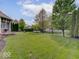 Well-maintained backyard featuring a spacious lawn, mature trees, and a black fence enclosing the property at 6648 Westminster Dr, Zionsville, IN 46077