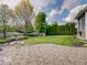 Lush backyard featuring a stone patio and well-manicured lawn, ideal for outdoor entertaining and relaxation at 6648 Westminster Dr, Zionsville, IN 46077