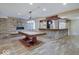 Spacious finished basement featuring a billiards table and a full stone bar with modern amenities at 6648 Westminster Dr, Zionsville, IN 46077