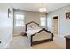 Cozy bedroom featuring a decorative headboard, neutral carpet, and two windows at 6648 Westminster Dr, Zionsville, IN 46077