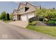 Side view of a two-story home with an attached three-car garage and well-maintained landscaping at 6648 Westminster Dr, Zionsville, IN 46077
