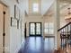 Inviting foyer with hardwood floors, offering views of the dining room and decorative glass front door at 6648 Westminster Dr, Zionsville, IN 46077