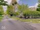 Street view showing a home with a black metal fence surrounded by green trees and landscaping at 6648 Westminster Dr, Zionsville, IN 46077