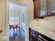 View of wet bar featuring dark wood cabinets, wine cooler, and light granite countertop at 6648 Westminster Dr, Zionsville, IN 46077