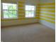 Bedroom with yellow and white striped accent wall and carpeted floors at 6836 Eagle Crossing Blvd, Brownsburg, IN 46112