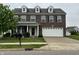 Brick two-story home with attached two car garage, green lawn, and mature shade tree at 6836 Eagle Crossing Blvd, Brownsburg, IN 46112