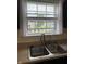 Kitchen sink features a double basin, stainless steel faucet, and a window providing natural light at 6836 Eagle Crossing Blvd, Brownsburg, IN 46112