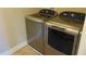 The image captures the laundry room's newer gray, front-loading washer and dryer on a tile floor at 6836 Eagle Crossing Blvd, Brownsburg, IN 46112
