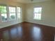 Bright living room featuring hardwood floors and multiple windows offering natural light at 6836 Eagle Crossing Blvd, Brownsburg, IN 46112