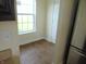 The image shows a mud room with tile flooring, a view outside, a stainless steel refrigerator, and a white door at 6836 Eagle Crossing Blvd, Brownsburg, IN 46112