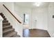 Welcoming foyer with hardwood floors, a staircase, and a front door, leading to a bright and open living space at 6843 Black Cherry Ter, Brownsburg, IN 46112