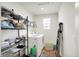 A functional laundry room with a window, washer, dryer and shelving at 6843 Black Cherry Ter, Brownsburg, IN 46112