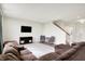 Bright living room with a large sectional sofa, TV, and a view of the staircase and front entrance at 6843 Black Cherry Ter, Brownsburg, IN 46112