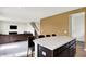Open-concept living room and kitchen with an island featuring bar seating, adjacent to a comfortable living space at 6843 Black Cherry Ter, Brownsburg, IN 46112
