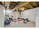 Unfinished basement with exercise equipment, neutral carpet, and exposed ceiling at 7060 N Park Ave, Indianapolis, IN 46220