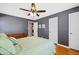 A view of the primary bedroom with gray walls, a ceiling fan, and connecting door at 7060 N Park Ave, Indianapolis, IN 46220