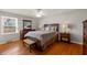 Well-lit main bedroom features hardwood floors, ceiling fan, and comfortable furnishings at 7060 N Park Ave, Indianapolis, IN 46220
