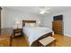 Cozy main bedroom with hardwood floors and a ceiling fan, features a large bed, dresser, and nightstands at 7060 N Park Ave, Indianapolis, IN 46220