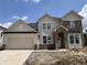 Charming two-story home with attached two car garage featuring neutral siding and brick accents at 7239 Barrett Dr, Brownsburg, IN 46112
