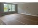 Spacious living room featuring large windows, neutral walls, and temporary floor protection at 7239 Barrett Dr, Brownsburg, IN 46112