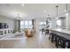 Bright living room has a cozy leather couch, modern chandelier, and plenty of natural light at 7239 Barrett Dr, Brownsburg, IN 46112
