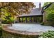 A rear stone patio with a brick retaining wall and multiple doors to the interior at 7406 N Washington Blvd, Indianapolis, IN 46240