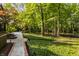 Lush backyard featuring a stone and brick walkway, leading to a tranquil wooded area at 7406 N Washington Blvd, Indianapolis, IN 46240