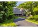 Charming Tudor-style home featuring a brick facade, inviting driveway, and professionally landscaped yard at 7406 N Washington Blvd, Indianapolis, IN 46240