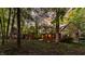 Beautiful Tudor-style home with manicured lawn and landscape, viewed through mature trees at 7406 N Washington Blvd, Indianapolis, IN 46240