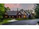 Charming Tudor-style home featuring a brick facade, inviting driveway, and professionally landscaped yard at 7406 N Washington Blvd, Indianapolis, IN 46240