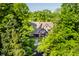 Charming Tudor-style home with lush landscaping and mature trees creating a private, picturesque setting at 7406 N Washington Blvd, Indianapolis, IN 46240