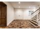 Spacious foyer with tile floors, a staircase, and a door to the side, neutral wall color at 7406 N Washington Blvd, Indianapolis, IN 46240