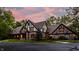 Stately Tudor-style house with brick and timber accents, lush landscaping, and driveway at 7406 N Washington Blvd, Indianapolis, IN 46240
