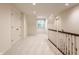 Hallway featuring carpet, a window, white trim, and a staircase with white banister at 7406 N Washington Blvd, Indianapolis, IN 46240