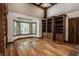 Living room featuring hardwood floors, built-in bookshelves, and large bay windows at 7406 N Washington Blvd, Indianapolis, IN 46240