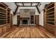 Living room with a brick fireplace, beamed ceilings, hardwood floors, and built-in shelving at 7406 N Washington Blvd, Indianapolis, IN 46240