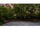 Stone patio with a retaining wall surrounded by mature trees offering private outdoor space at 7406 N Washington Blvd, Indianapolis, IN 46240