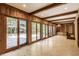 Bright sunroom with wood paneling, tile flooring, and multiple doors to the outside at 7406 N Washington Blvd, Indianapolis, IN 46240