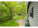 Scenic backyard with lush greenery, a stone path, and a charming woodshed tucked away in the trees at 7595 Heather Dr, Nineveh, IN 46164
