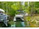 Waterfront property with private boat dock, boat slip, and steps leading to the wooded backyard at 7595 Heather Dr, Nineveh, IN 46164