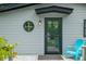 Close up on charming exterior featuring a round window, modern door, and teal Adirondack chair at 7595 Heather Dr, Nineveh, IN 46164