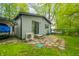 Back exterior view with patio, wooded backdrop, and outdoor utilities at 7595 Heather Dr, Nineveh, IN 46164