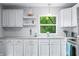 A beautiful white kitchen with stainless steel sink and appliances, with white beadboard backsplash at 7595 Heather Dr, Nineveh, IN 46164