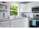 Kitchenette features stainless steel appliances, white cabinets and a view of the outdoors at 7595 Heather Dr, Nineveh, IN 46164