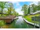 Scenic waterfront view with boat docks and lush trees and home in the background at 7595 Heather Dr, Nineveh, IN 46164