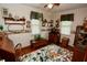 Bright bedroom featuring natural light, wood flooring, and a charming mix of vintage and floral decor at 76 Manhattan Ave, Indianapolis, IN 46241